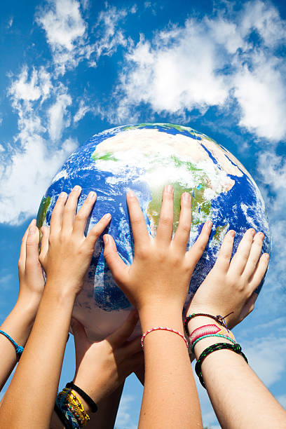 People stacking hands, earth in center