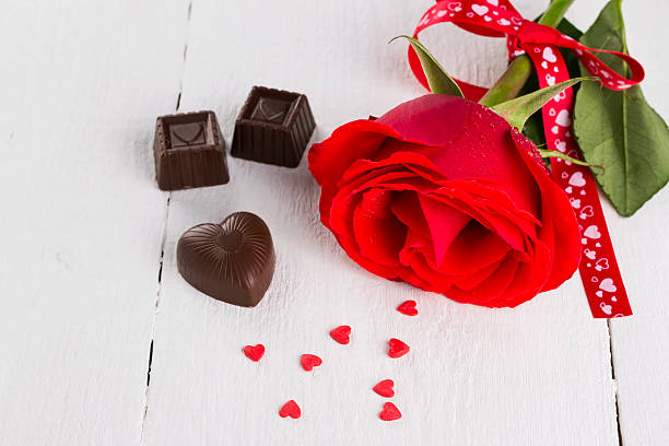 istock Red rose, chocolates on a white wooden background 518197694