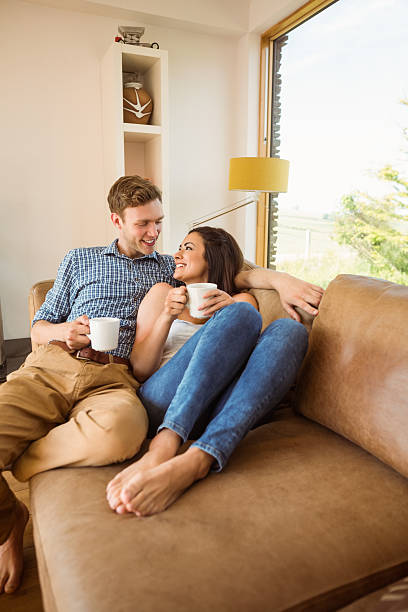 istock Happy young couple relaxing on the couch 518197855