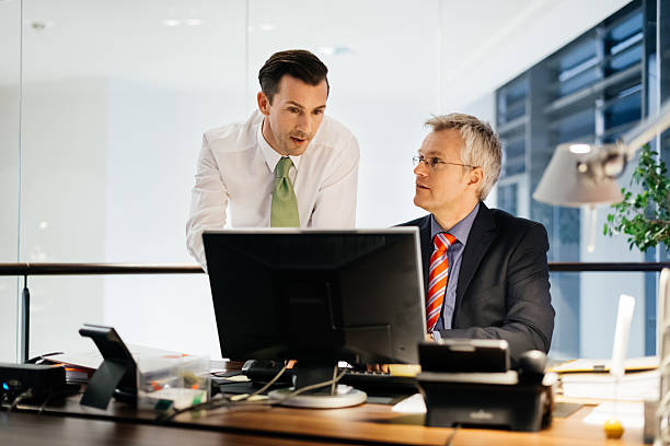 istock Two Business Men Working Late in illuminated office 518198064