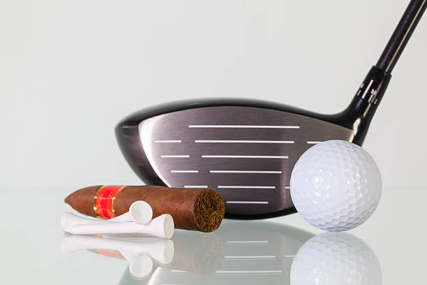 istock Golf driver and different cigars on a glass desk 518198394