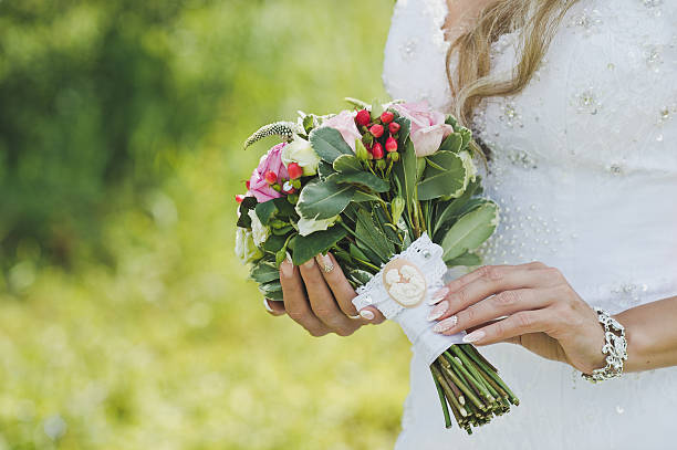 Bouquet in hands of bride Bouquet of white and pink roses in hands of bride. bride holding bouquet stock pictures, royalty-free photos & images