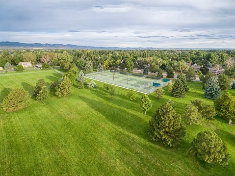 aerial view of one of parks in Fort Collins, Colorado, with a large grass field and tennis courts, summer morning