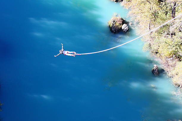 Bungee jump Girl bungee jumping above the river. bungee jumping stock pictures, royalty-free photos & images