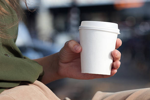 молодая женщина, пить кофе в одноразовые стаканы - coffee cup cup disposable cup take out food стоковые фото и изображения
