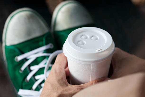 istock Young woman drinking coffee from disposable cup 518204087