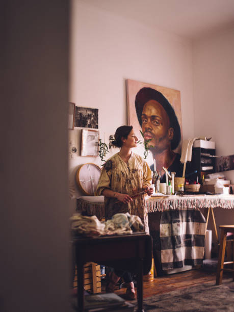 Artist in her studio with her art equipment thinking