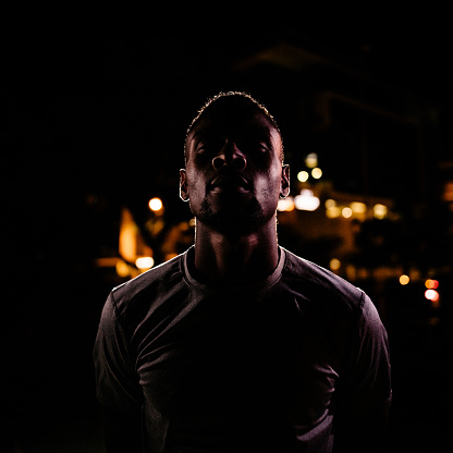 African American male basketball player with challenging face, ready to play a game of nighttime street ball