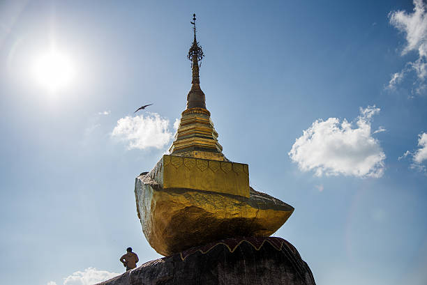 Man looking at the sky next to a Stupa at Golden Rock area in Myanmar, Asia.