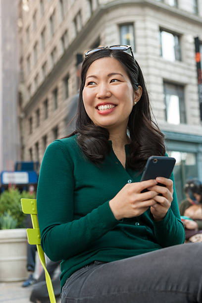 istock Young asian woman texting on smartphone 518210682