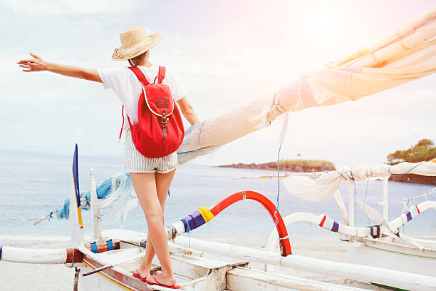 istock Young woman with hat and backpack walking on sailboat 518211826