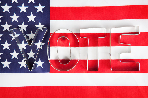 The word VOTE spelled out on top of an American flag.