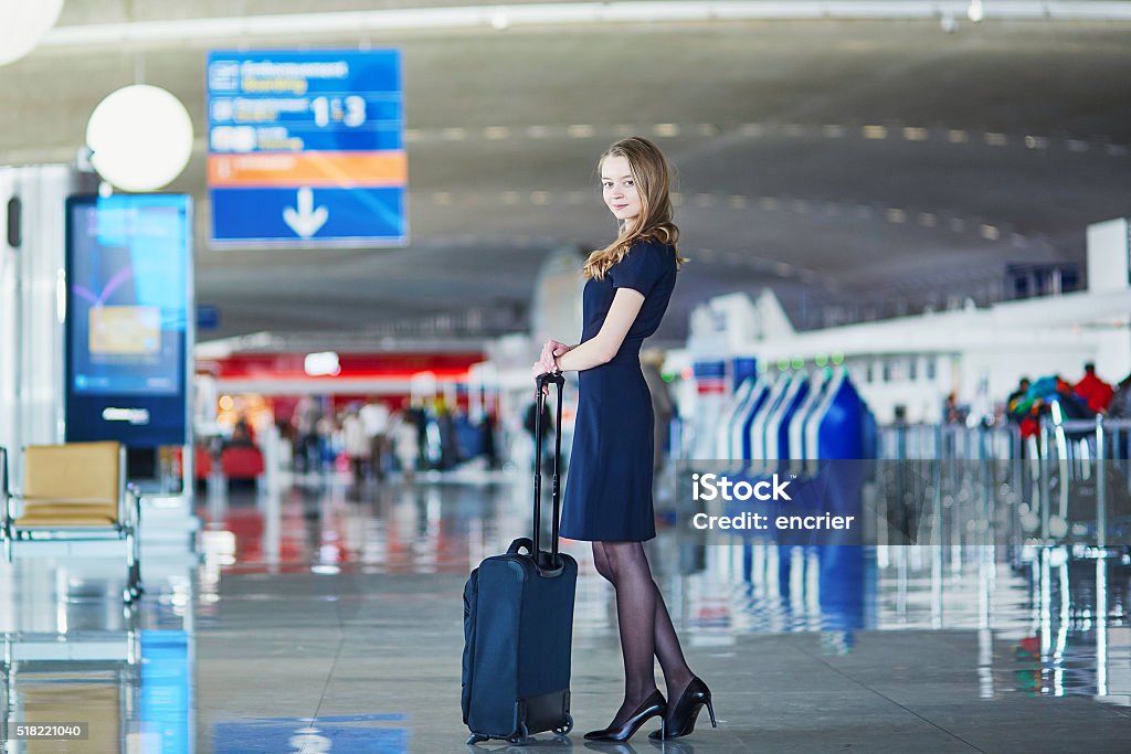 Young female traveler in international airport Beautiful female passenger or flight attendant in international airport with hand luggage Adult Stock Photo