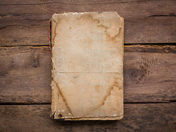 istock Old book on wood background 518222631