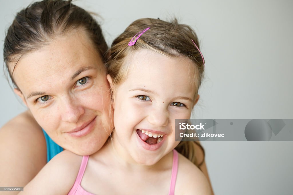 Portrait of mother and daughter embracing, smiling Mother and daughter embracing, smiling, being affectionate, happy and loving. Parenthood, childhood, happiness and family life concept. Grey seamless background. Mother Stock Photo