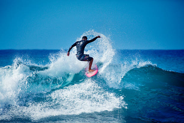 joven hombre surfista surf en el agua de hawai - big wave surfing fotografías e imágenes de stock