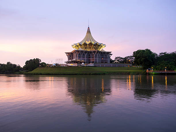 Architectural Landmark in Kuching, Sarawak, Malaysia Sunset at the waterfront in Kuching with the iconic New Sarawak State Legislative Assembly building by the Sarawak river. kuching waterfront stock pictures, royalty-free photos & images
