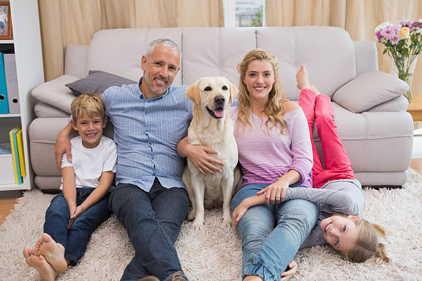 istock Parents and children on rug with labrador 518224235