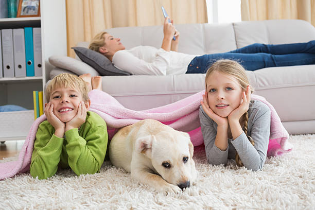 istock Cute silblings with their puppy on rug 518225227