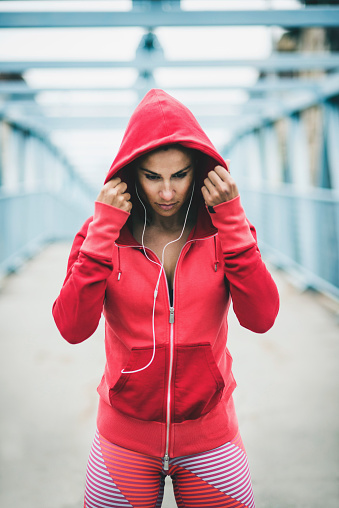 Portrait of young fitness woman listening to music and preparing for workout