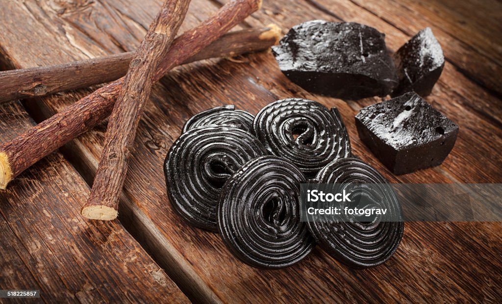 Production steps of licorice, roots, pure blocks and candy. Production steps of licorice, roots, pure blocks and candy on wooden table Licorice Root Stock Photo
