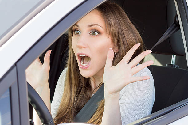istock Frightened young car driver woman look straight 518225966