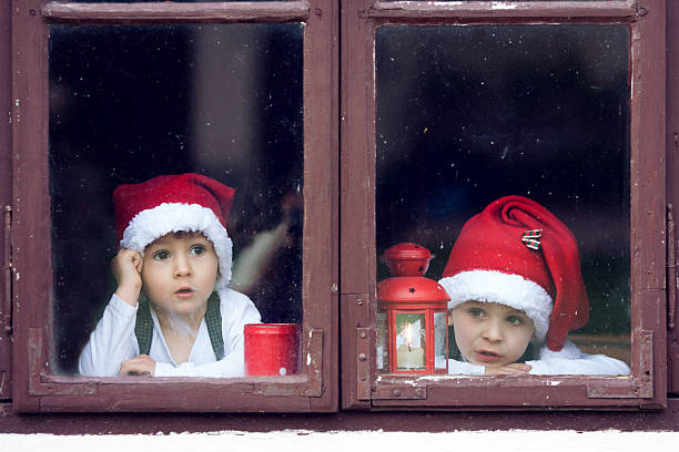 istock Two cute boys, looking through a window, waiting for Santa 518226563