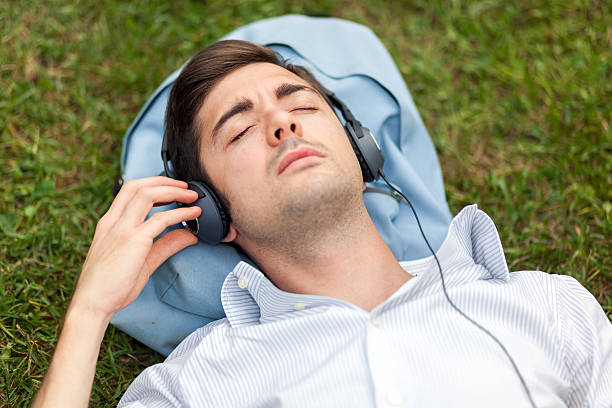 istock Young man listening music on the grass 518227374