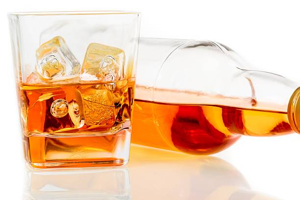 istock whiskey near bottle on white background with reflection 518228968