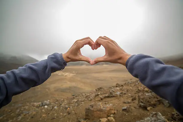 Photo of Personal perspective of woman making heart shape finger frame