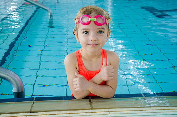 urocza dziewczynka w basenie - swimming child swimming pool indoors zdjęcia i obrazy z banku zdjęć