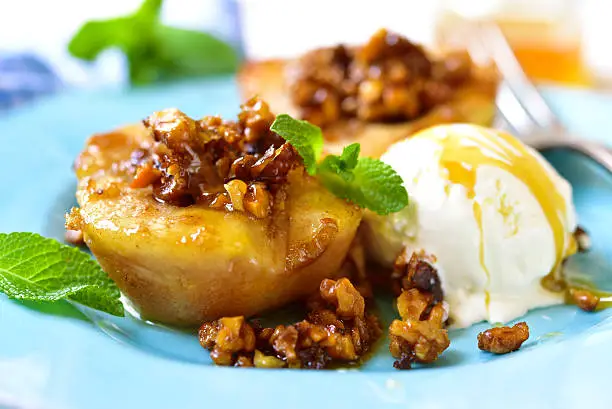 Grilled pear with caramelized walnuts and honey on a blue vintage plate.