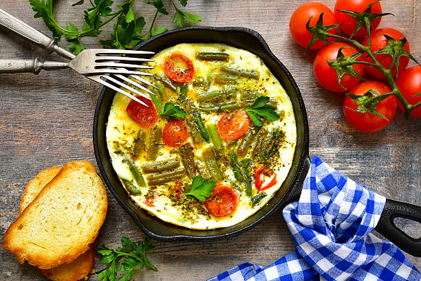 omelette aux tomates et haricots d'asperges. - plate silverware table white photos et images de collection