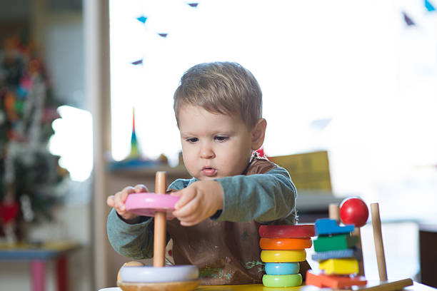 Little caucasian boy playing with Montessori toy in pre-school Little caucasian boy playing with Montessori toy in pre-school montessori education stock pictures, royalty-free photos & images