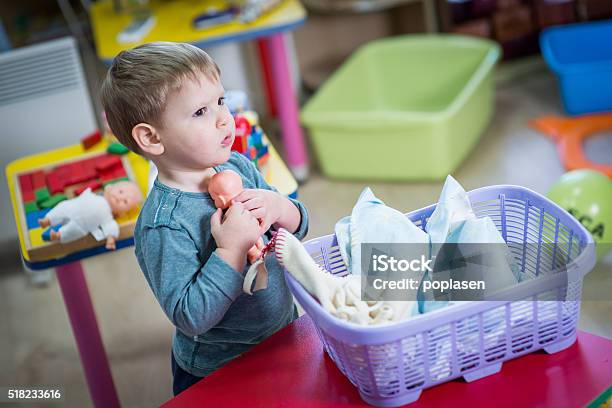 Little Boy Plays With A Doll Stock Photo - Download Image Now - Doll, Boys, Child