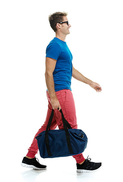 istock Smiling man holding bag and walking 518234034