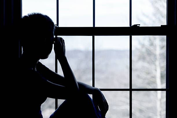 teenager girl looks outside into the window teenager girl looks outside into the window in the small hostel room with bunk bed hotel window view stock pictures, royalty-free photos & images