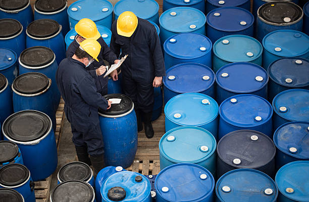 Men working at a chemical warehouse Group of men working at a chemical warehouse classifying barrels chemical stock pictures, royalty-free photos & images