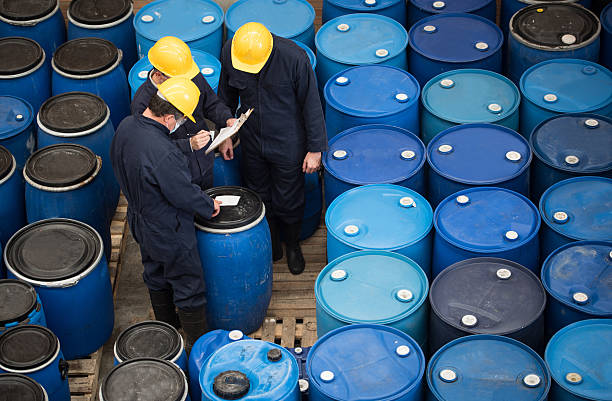 Men working at a chemical warehouse Group of men working at a chemical warehouse classifying barrels chemical plant stock pictures, royalty-free photos & images