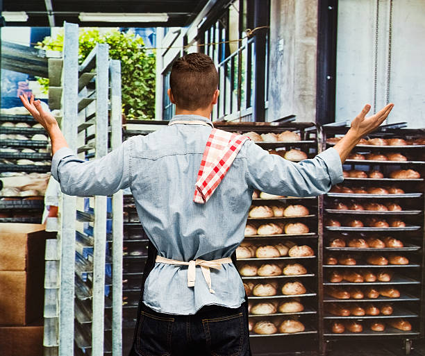 istock Rear view of baker with arms outstretched 518247878
