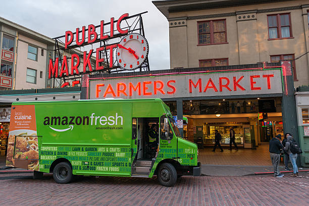 Amazon Fresh Seattle, USA - February 2, 2016: An Amazon Fresh truck in front of the famous Pike Place Market late in the day. elliott bay photos stock pictures, royalty-free photos & images