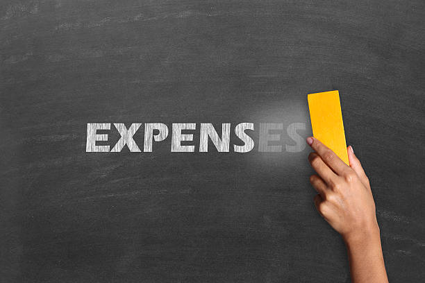 Cost cutting concept Changing word Expenses into expense. Close-up of a person hand holding duster and cleaning blackboard written the word "Expenses". Concept for recession or credit crisis. board eraser stock pictures, royalty-free photos & images