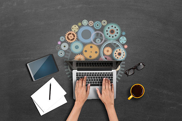 istock Businesswomen using laptop with gears 518250294
