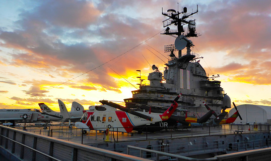 Military carrier turrets and weapons on warship at sunset close-up