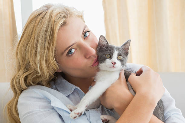istock Pretty blonde with pet kitten on sofa 518257257