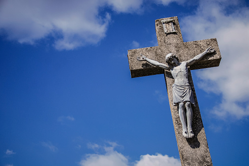 Jesus statue on a stone cross.