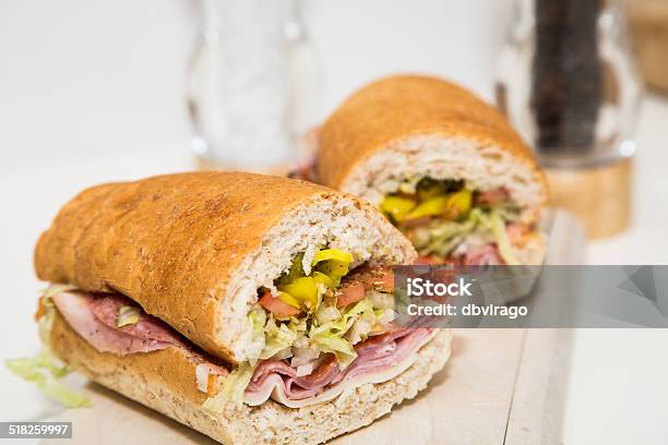 Cut Italian Sub On Wood Cutting Board Stock Photo - Download Image Now - Baguette, Bread, Bun - Bread