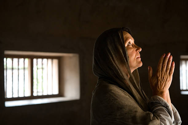 istock Praying mature woman 518264011