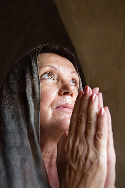 istock Praying mature woman 518264013