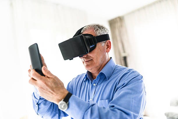 istock mature man entartains his self with virtual reality device simulator 518272848